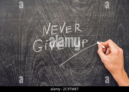 Never give up words written on the chalkboard Stock Photo