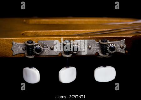 Acoustic guitar machine heads isolated on dark background Stock Photo