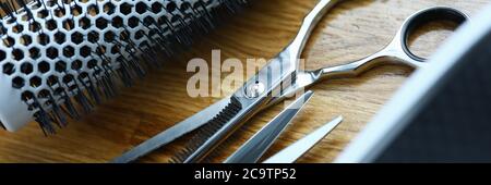 Clipper and comb lie on wooden table in hairdresser closeup Stock Photo