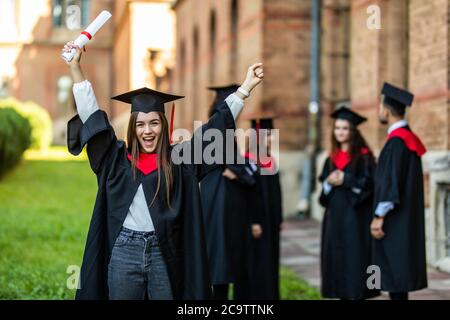 Group of graduate students holding their diploma after graduation Stock Photo