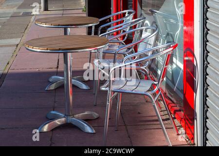 empty tables and chairs outside a restaurant normally filled with customers dining Stock Photo