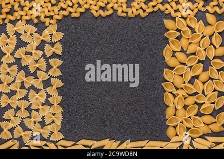 Different types of pasta on grey background. Frame out of macaroni Stock Photo