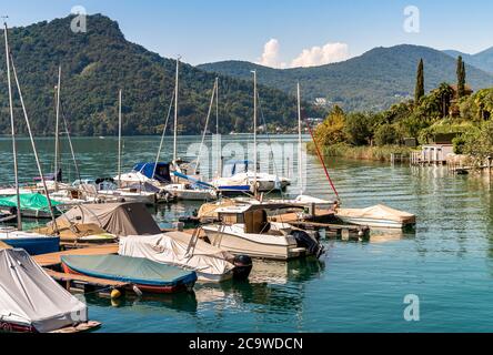 Pier with boats on Lake Lugano in Morcote, Ticino, Switzerland Stock Photo