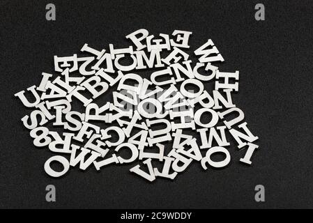Letters of Latin alphabet arranged in chaotic order. Black background Stock Photo