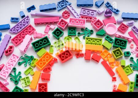 Toys background. Colorful cubes and plastic construction blocks frame on white background.Frame from different shapes plastic blocks.Creative, logical Stock Photo