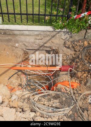 Repair work on the city street. A freshly dug trench is fenced with a ...