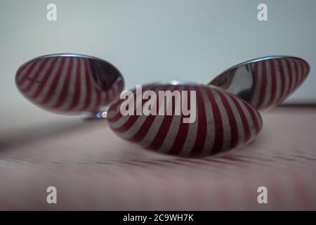Three spoons composed to reflect red vertical lines Stock Photo