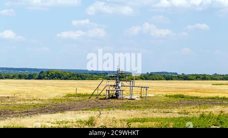 Landscape with the oil well Christmas tree in the field Stock Photo