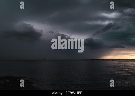 Stormy powerful clouds by the ocean during sunset in the southern archipelago of Gothenburg, Sweden Stock Photo