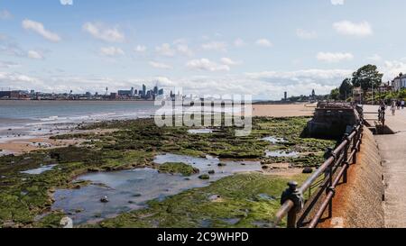 Liverpool skyline over the rockpools seen at low tide from the promenade at New Brighton in August 2020. Stock Photo