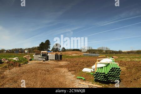 Bridgend, Wales - April 2018: Green drainage pipes and other building materials on ground which has been cleared for building Stock Photo