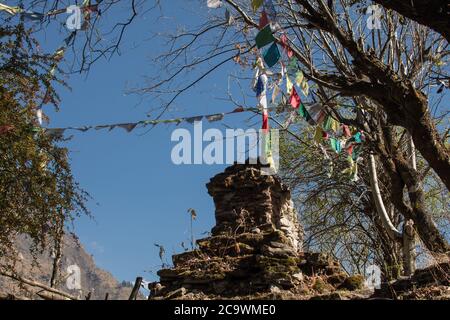 Colorful buddhist prayer flags hanging, blowing in the wind by the mountains at Annapurna circuit, Nepal Stock Photo