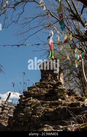 Colorful buddhist prayer flags hanging, blowing in the wind by the mountains at Annapurna circuit, Nepal Stock Photo