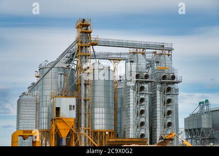 Agribusiness concept. Metal silos for grain storage, drying, cleaning agricultural products, flour, cereals and grain on agro-processing and manufactu Stock Photo