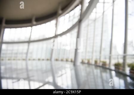 Blur background interior view looking out toward to empty office lobby and entrance doors and glass curtain wall Stock Photo