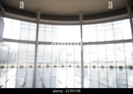 Blur background interior view looking out toward to empty office lobby and entrance doors and glass curtain wall Stock Photo