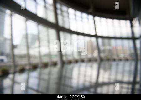 Blur background interior view looking out toward to empty office lobby and entrance doors and glass curtain wall Stock Photo