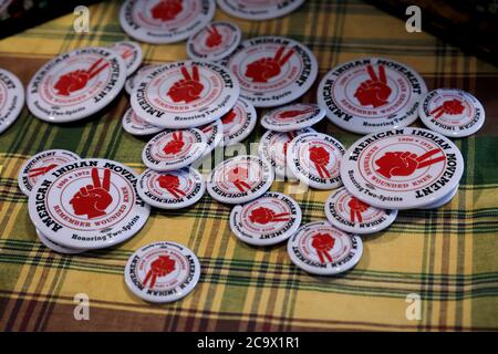 San Francisco, USA - February 08, 2020: Pins with the American Indian Movement symbol, inscription Remember Wounded Knee 1890 -1973 at a powwow Stock Photo