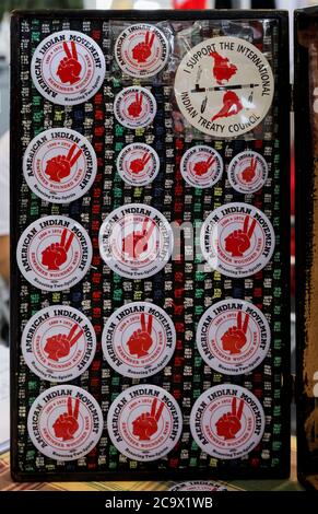 San Francisco, USA - February 08, 2020: Pins with the American Indian Movement symbol, inscription Remember Wounded Knee 1890 -1973 at a powwow Stock Photo