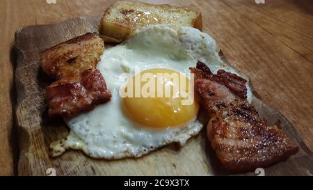 photo close-up view of fried eggs with slices of fried bacon and croutons Stock Photo