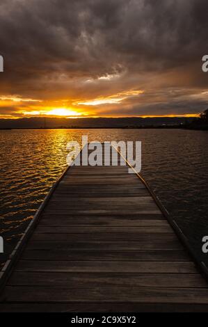 Sunset view along a wooden pier of the western side of the Port Pirie harbour in South Australia. Stock Photo