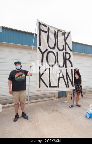 Zinc, Arkansas, USA. 2nd Aug, 2020. Aug. 2, 2020: Protesters hold up signs along Zinc Road which leads to the compound of the KKK. A variety of groups including Ozarks Hate Watch and Bridge the Gap NWA are marching on Zinc, AR, in a historic march (never before has Zinc had a march of Black groups). Zinc is home of Thomas Robb, who is the grandwizard of the KKK. Credit: Leslie Spurlock/ZUMA Wire/Alamy Live News Stock Photo