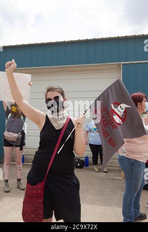 Zinc, Arkansas, USA. 2nd Aug, 2020. Aug. 2, 2020: Protesters hold up signs along Zinc Road which leads to the compound of the KKK. A variety of groups including Ozarks Hate Watch and Bridge the Gap NWA are marching on Zinc, AR, in a historic march (never before has Zinc had a march of Black groups). Zinc is home of Thomas Robb, who is the grandwizard of the KKK. Credit: Leslie Spurlock/ZUMA Wire/Alamy Live News Stock Photo