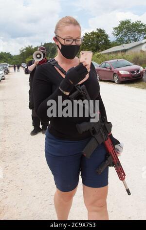 Zinc, Arkansas, USA. 2nd Aug, 2020. Aug. 2, 2020: An armed female protesters walks along Zinc Road during the protest. A variety of groups including Ozarks Hate Watch and Bridge the Gap NWA are marching on Zinc, AR, in a historic march (never before has Zinc had a march of Black groups). Zinc is home of Thomas Robb, who is the grandwizard of the KKK. Credit: Leslie Spurlock/ZUMA Wire/Alamy Live News Stock Photo