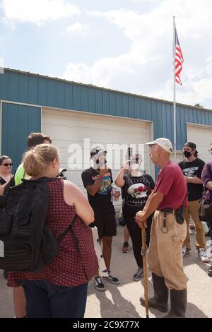 Zinc, Arkansas, USA. 2nd Aug, 2020. Aug. 2, 2020: Protesters and a members of the opposition engage in dialogue. A variety of groups including Ozarks Hate Watch and Bridge the Gap NWA are marching on Zinc, AR, in a historic march (never before has Zinc had a march of Black groups). Zinc is home of Thomas Robb, who is the grandwizard of the KKK. Credit: Leslie Spurlock/ZUMA Wire/Alamy Live News Stock Photo