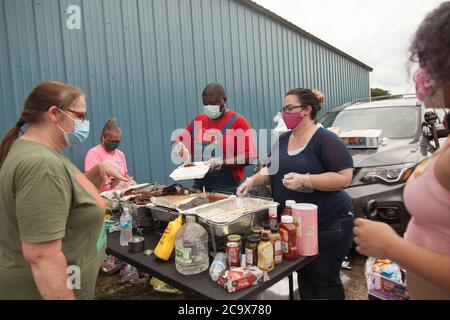 Zinc, Arkansas, USA. 2nd Aug, 2020. Aug. 2, 2020: Protesters serve bbq to everyone that wants some, including the opposition. A variety of groups including Ozarks Hate Watch and Bridge the Gap NWA are marching on Zinc, AR, in a historic march (never before has Zinc had a march of Black groups). Zinc is home of Thomas Robb, who is the grandwizard of the KKK. Credit: Leslie Spurlock/ZUMA Wire/Alamy Live News Stock Photo