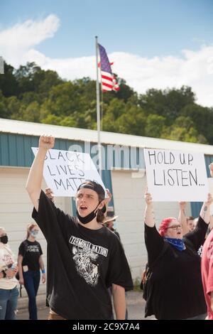 Zinc, Arkansas, USA. 2nd Aug, 2020. Aug. 2, 2020: Protesters hold up signs along Zinc Road which leads to the compound of the KKK. A variety of groups including Ozarks Hate Watch and Bridge the Gap NWA are marching on Zinc, AR, in a historic march (never before has Zinc had a march of Black groups). Zinc is home of Thomas Robb, who is the grandwizard of the KKK. Credit: Leslie Spurlock/ZUMA Wire/Alamy Live News Stock Photo