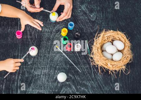 Happy easter A mother, father and their son painting Easter eggs. Happy family preparing for Easter Stock Photo