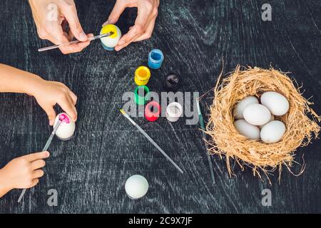 Happy easter A mother, father and their son painting Easter eggs. Happy family preparing for Easter Stock Photo