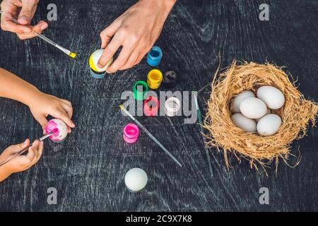 Happy easter A mother, father and their son painting Easter eggs. Happy family preparing for Easter Stock Photo