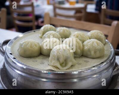 Jjin mandu, or Korean style steamed dumpling filled with a mixture of ingredients including ground pork, kimchi, vegetables, cellophane noodles. Stock Photo