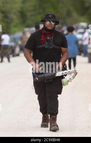 Zinc, Arkansas, USA. 2nd Aug, 2020. QUINN FOSTER of Ozarks Hate Watch carries a flame thrower as he protests along Zinc Road. A variety of groups including Ozarks Hate Watch and Bridge the Gap NWA are marching on Zinc, home of Thomas Robb, who is the grandwizard of the KKK. Never before has Zinc had a march of Black groups. Credit: Leslie Spurlock/ZUMA Wire/Alamy Live News Stock Photo