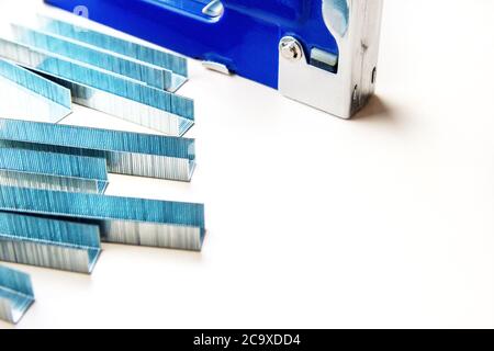 Blue industrial stapler gun with staples, furniture industry hardware with copy space Stock Photo