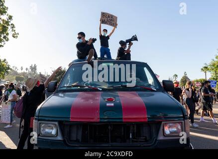 La Mesa, California, USA. 1st Aug, 2020. Participants in a Black Lives Matter protest in La Mesa, California, pass through the crowd while riding atop a van on August 1, 2020. Credit: David Barak/ZUMA Wire/Alamy Live News Stock Photo