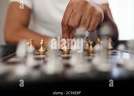 Close-up image of man playing chess at home, selective focus Stock Photo