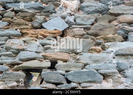Stone and rock wall background. Vintage gray green color stone wall background and texture, Traditional greek island architecture and construction Stock Photo