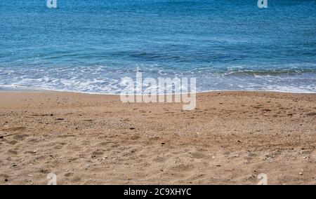 Sandy beach, soft waves rolling on the shore, calm sea water, beach  background empty early in the morning. Stock Photo