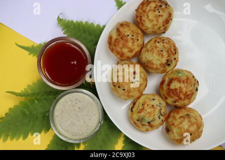 Appum or Appe, Appam or Mixed dal or Rava Appe served with green and red chutney. A Ball shape popular south Indian breakfast dish, Selective focus Stock Photo