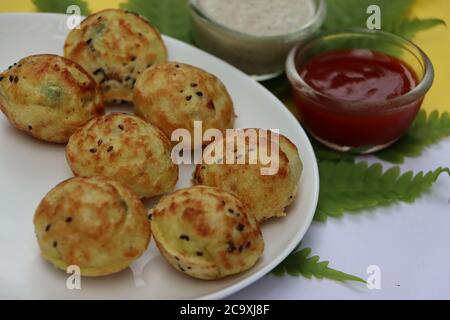 Appum or Appe, Appam or Mixed dal or Rava Appe served with green and red chutney. A Ball shape popular south Indian breakfast dish, Selective focus Stock Photo