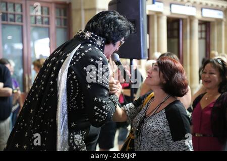 An Elvis impersonator entertains the crowds at Central Station in Sydney before the departure of the NSW Trainlink Elvis Express train to Parkes. Stock Photo