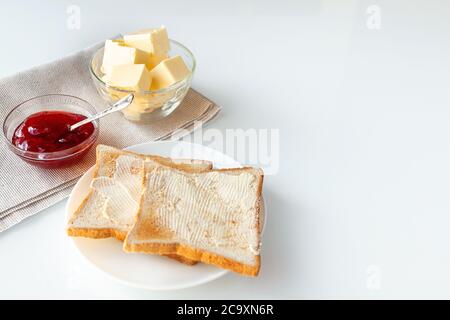 Toast bread, strawberry jam or marmalade and butter on table served for breakfast or brunch Stock Photo