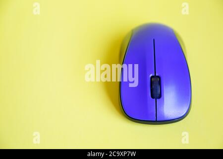 Top view of a blue wireless mouse on yellow background,  with copy space Stock Photo