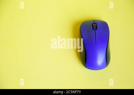 Top view of a blue wireless mouse on yellow background,  with copy space Stock Photo