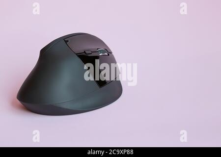 View of a black wireless mouse on pink background,  with copy space Stock Photo