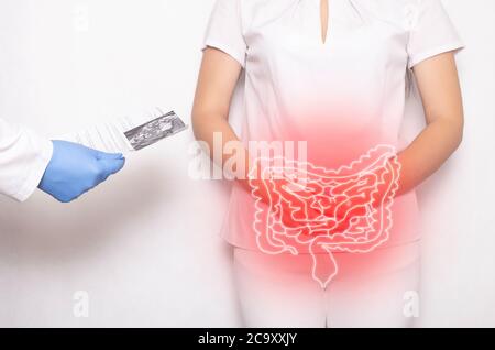 The doctor holds the results of the examination of the female patient on a white background. Bowel inflammation and disease concept, abdominal pain, d Stock Photo