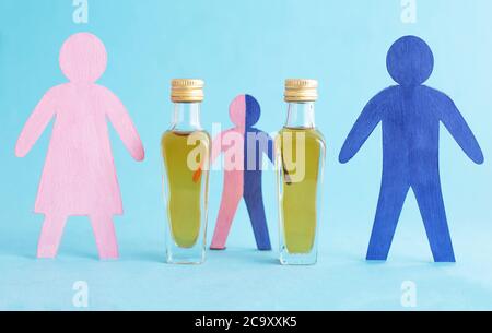 Wooden figurines in the form of people and bottles with alcohol on a blue background. Family alcoholism concept in family, alcoholism treatment, drink Stock Photo